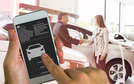 A person using a smartphone with a car inventory app while a salesperson and customer shake hands in a dealership.